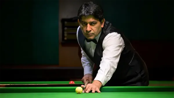 Geet Sethi lining up a shot at a billiards table